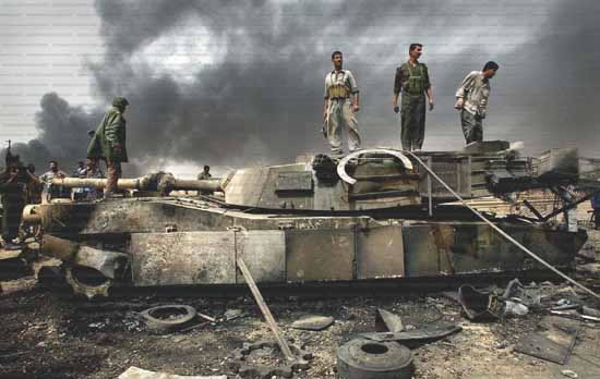 Combatientes de la resistencia iraquí sobre los restos de un tanque de ocupación yanqui